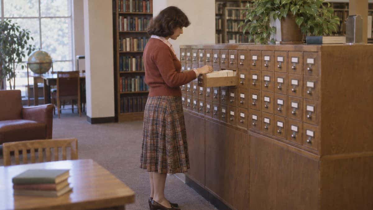 14 Things Teachers Swore We'd Need That We Haven't Used Since 1975 5 Someone flipping through a library card catalog