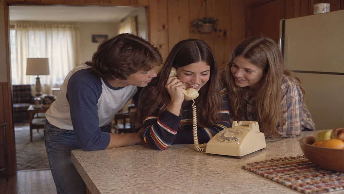 Before Screens: How We Entertained Ourselves 6 Teenagers huddled around a classic rotary phone.