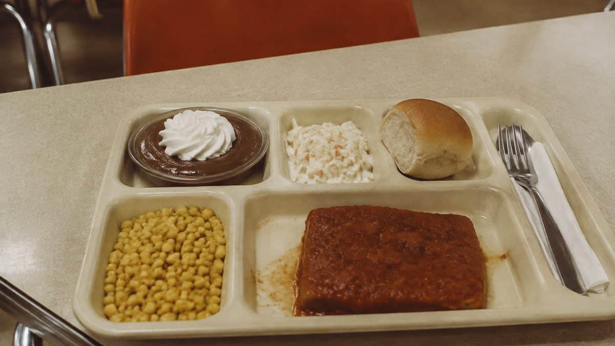 School Cafeteria Food from the '70s We Secretly Loved 4 Vintage-looking photo of a 1970s cafeteria tray with chocolate pudding.