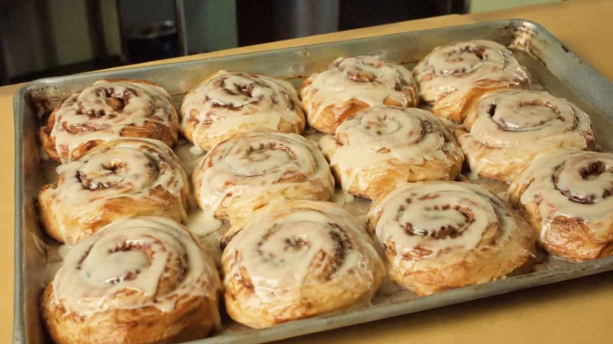 School Cafeteria Food from the '70s We Secretly Loved 8 Freshly baked cinnamon rolls on a standard baking sheet