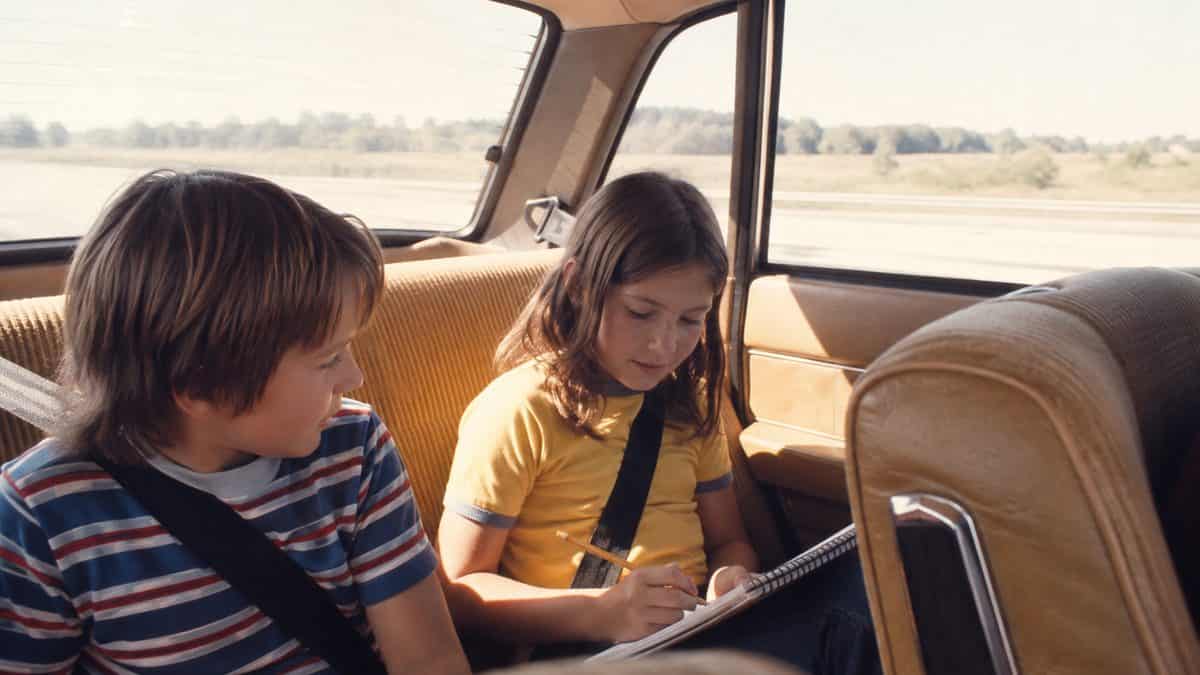 13 Family Road Trip Rituals from the '70s Nobody Does Anymore 5 Kids playing games in a car.