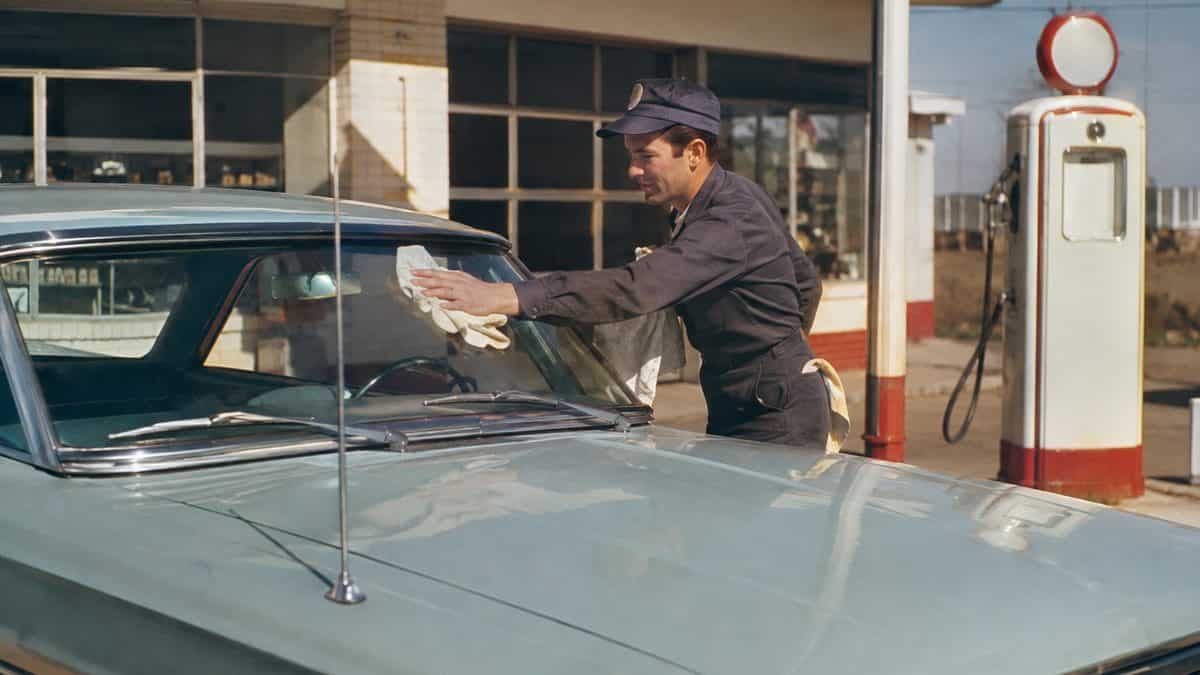 15 Gas Station Services We Took for Granted in the '60s 3 Gas station attendant washing a windshield