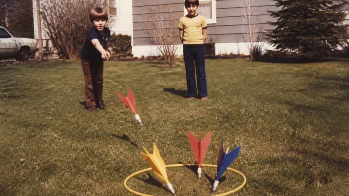 Backyard Games from the '70s That Kept Kids Outside Until Dark 2 Authentic vintage 1970s photograph of children playing in a backyard.