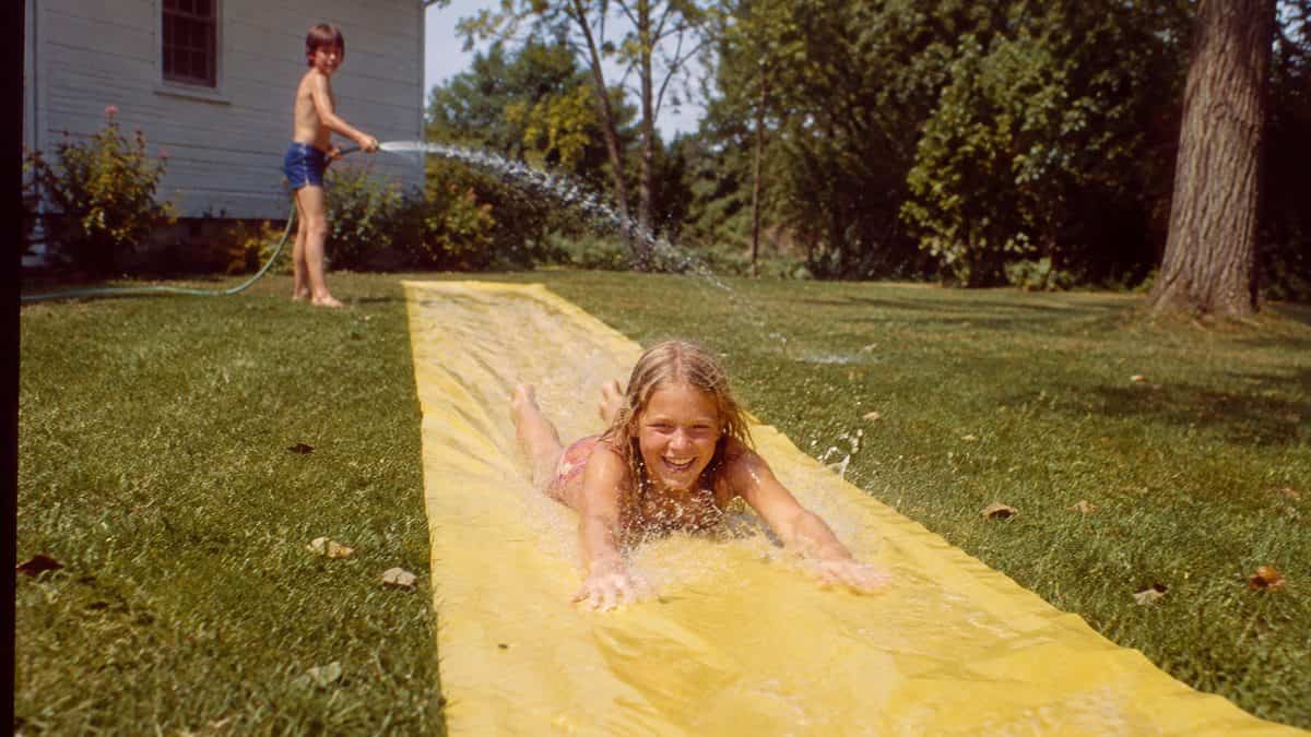 Backyard Games from the '70s That Kept Kids Outside Until Dark 4 Kids on a Slip 'N Slide.
