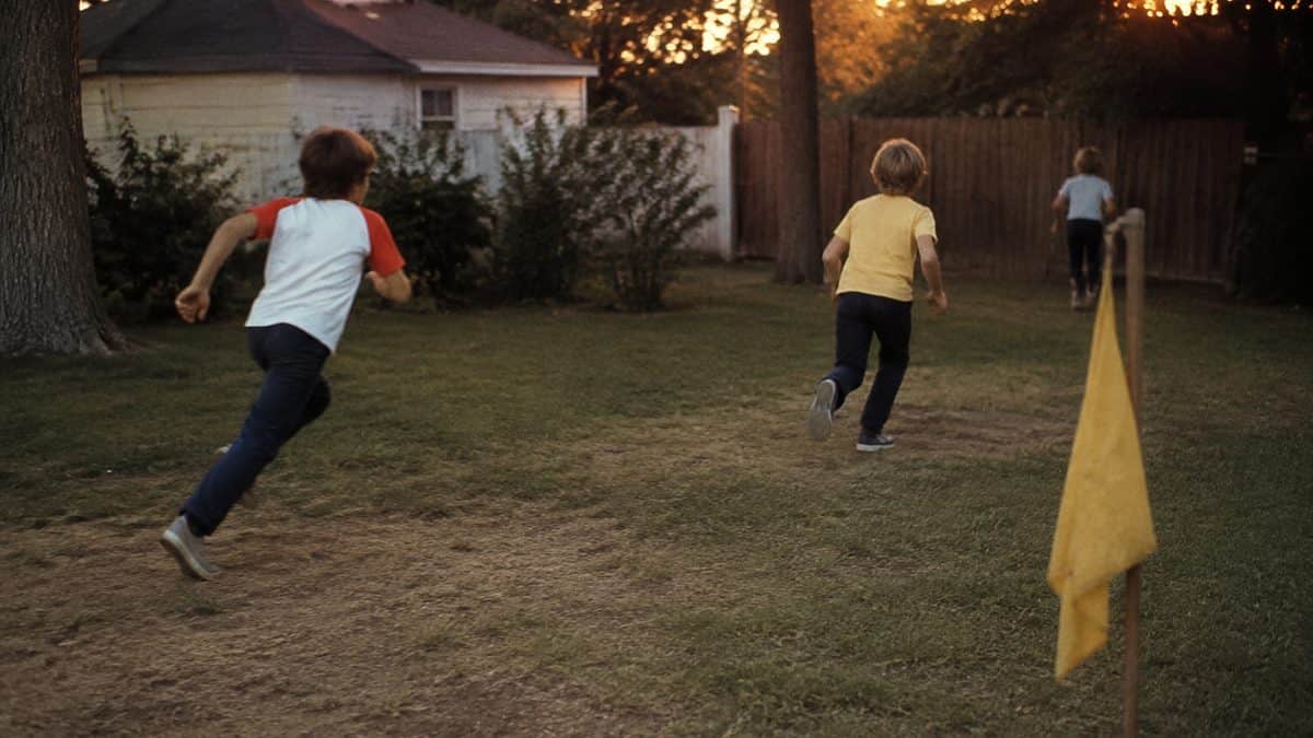 Backyard Games from the '70s That Kept Kids Outside Until Dark 9 Kids playing capture the flag or running at dusk.