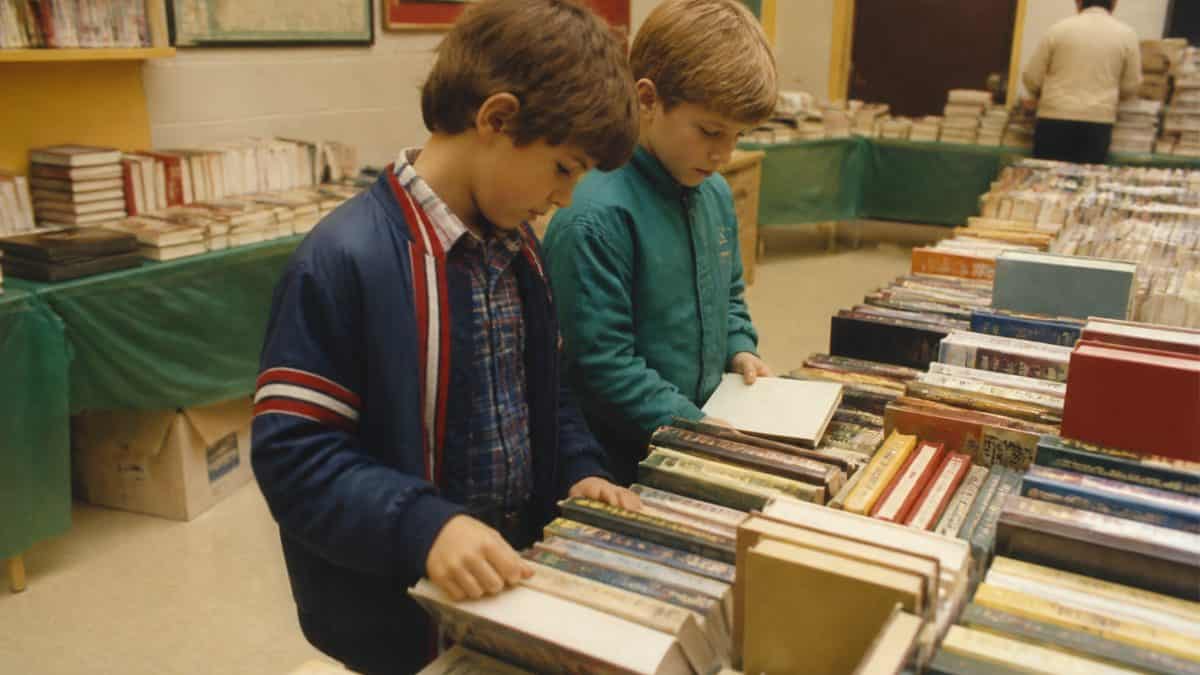 Authentic 1980s photo of kids at a school book fair.