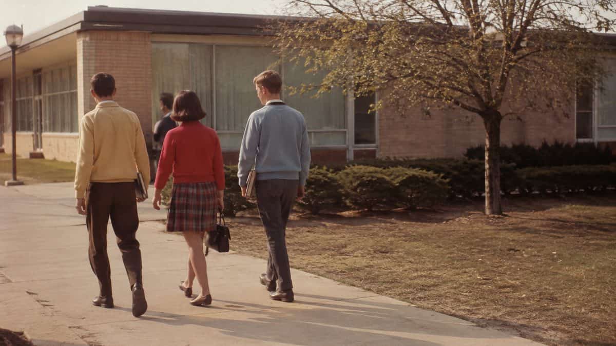 1960s high school students walking outside.