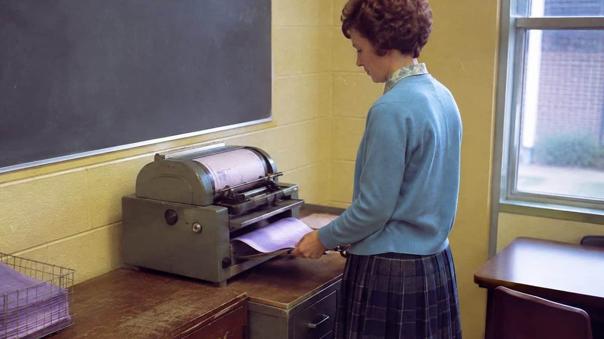 Teacher using a mimeograph machine.