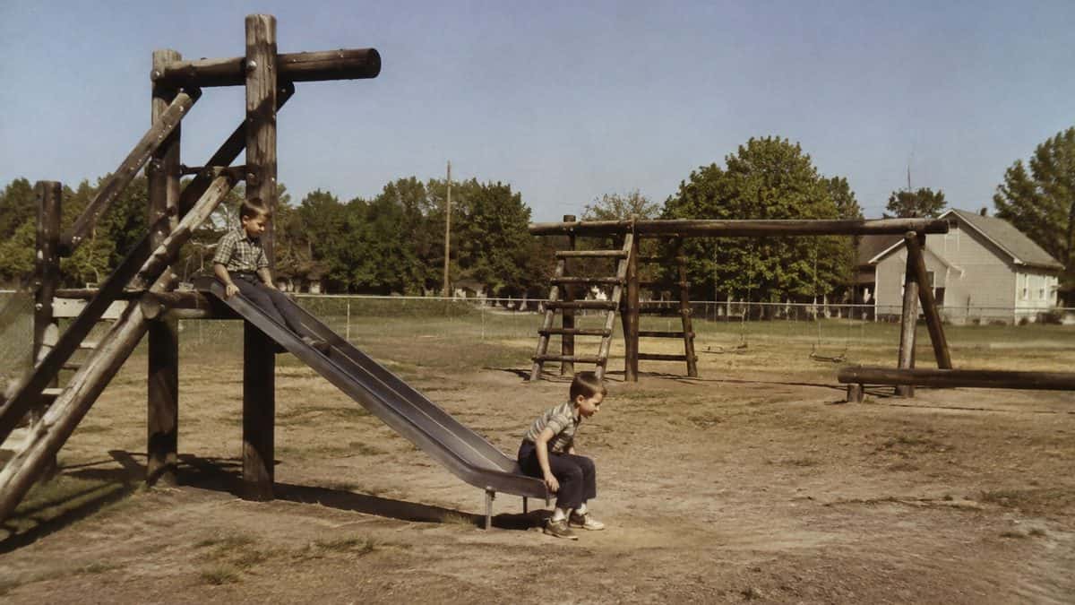 Real 1960s photo of kids on a wooden or metal playground