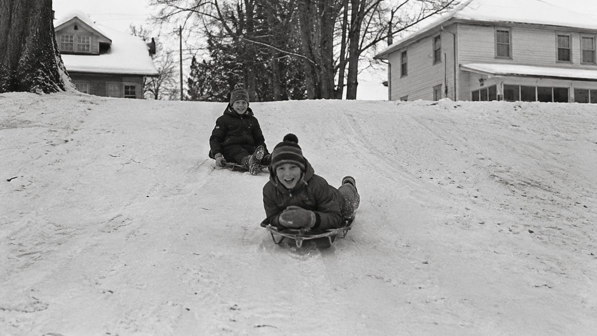 Authentic vintage black and white photo of kids sledding