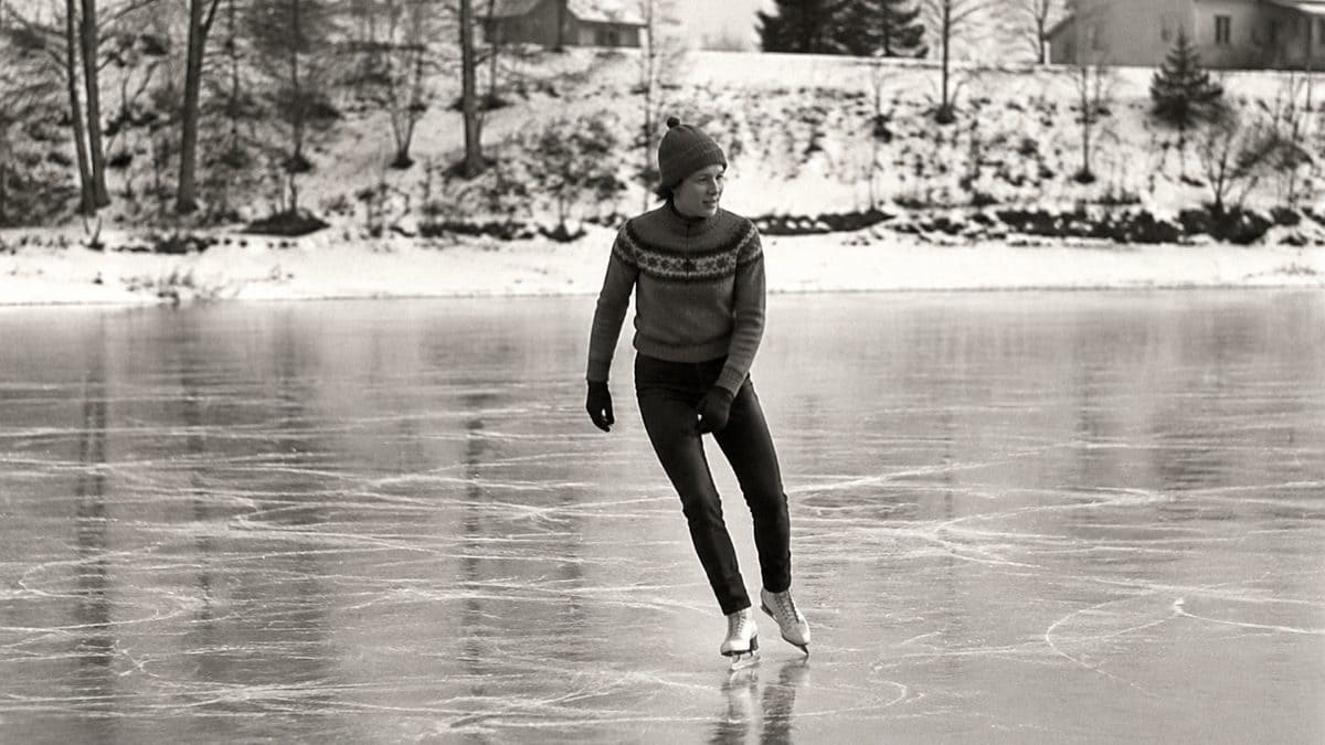 Authentic vintage black and white photo of a person ice skating on a pond.
