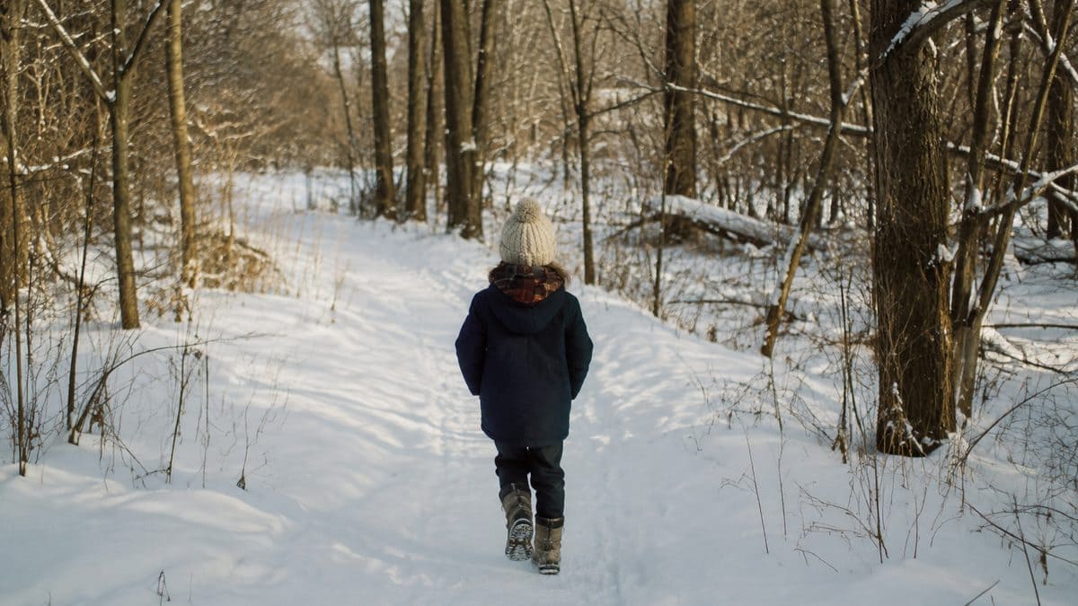 Child walking through a snowy park