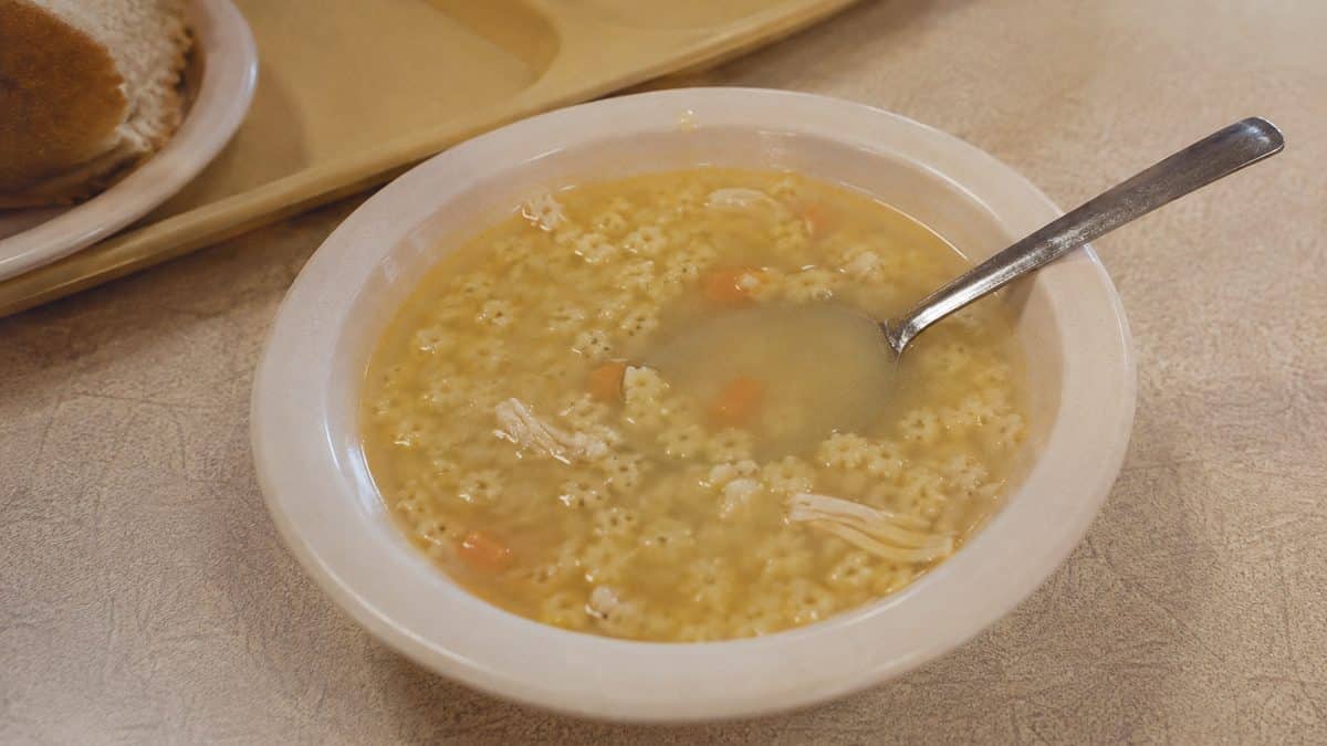 Chicken and stars soup with a spoon
