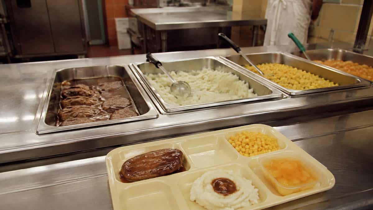 Authentic cafeteria line serving Salisbury steak with natural food textures