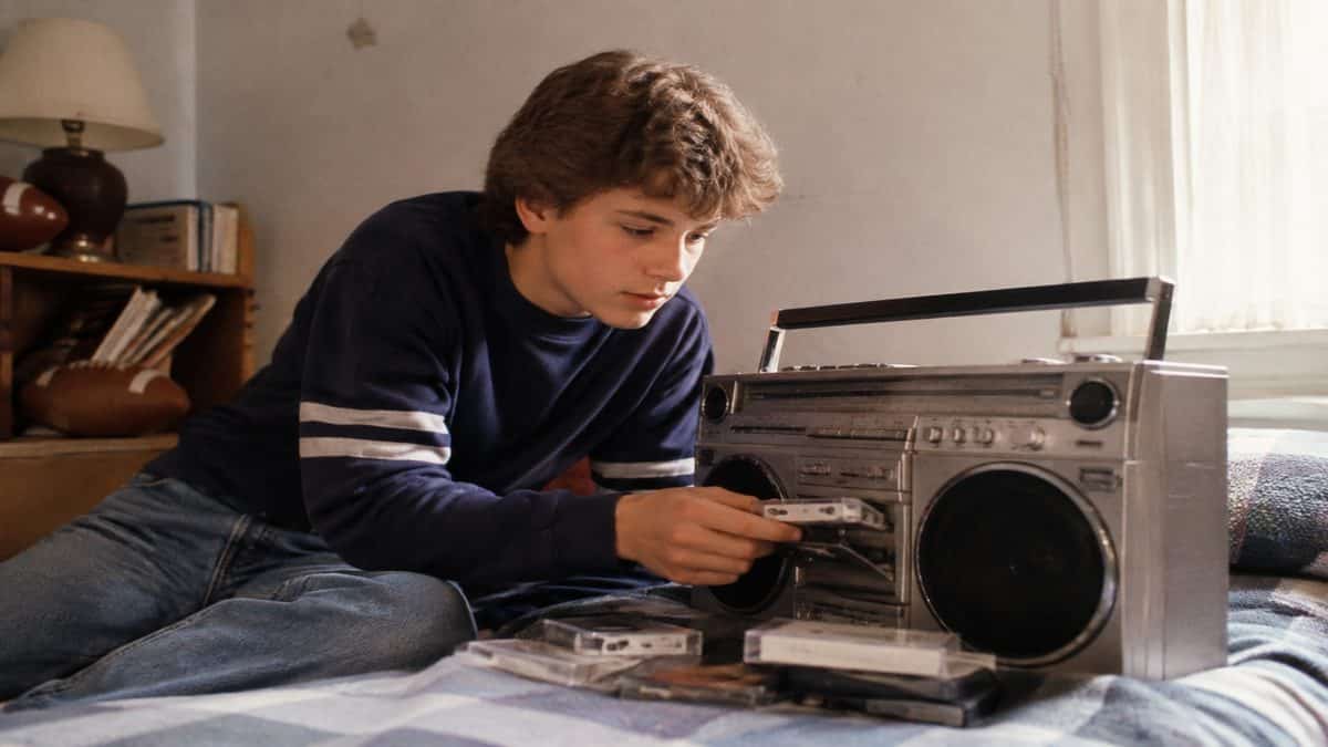 Teenager making a mixtape on a boombox.