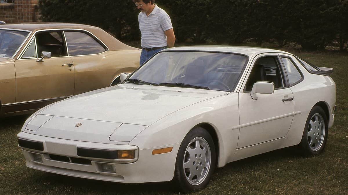 Porsche 944 Turbo at a car show with natural-looking people.