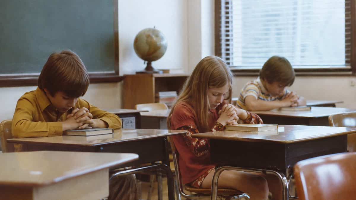 Students praying at desks