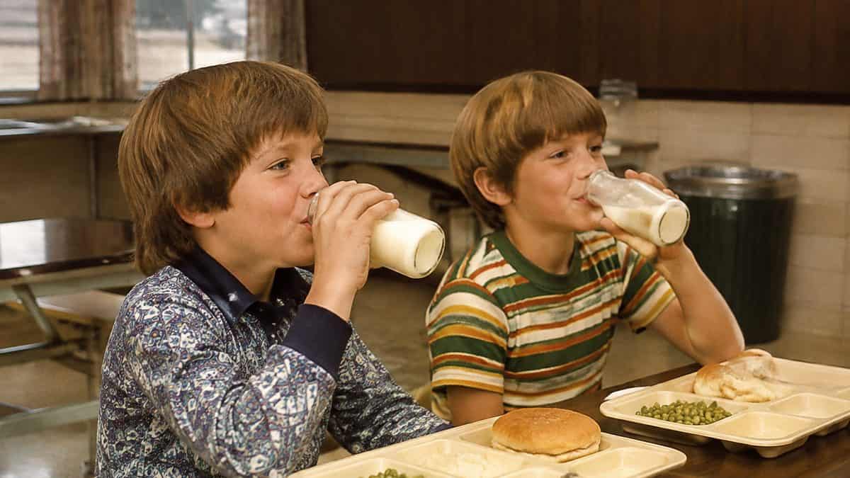 Students happily drinking milk in a 1970s cafeteria