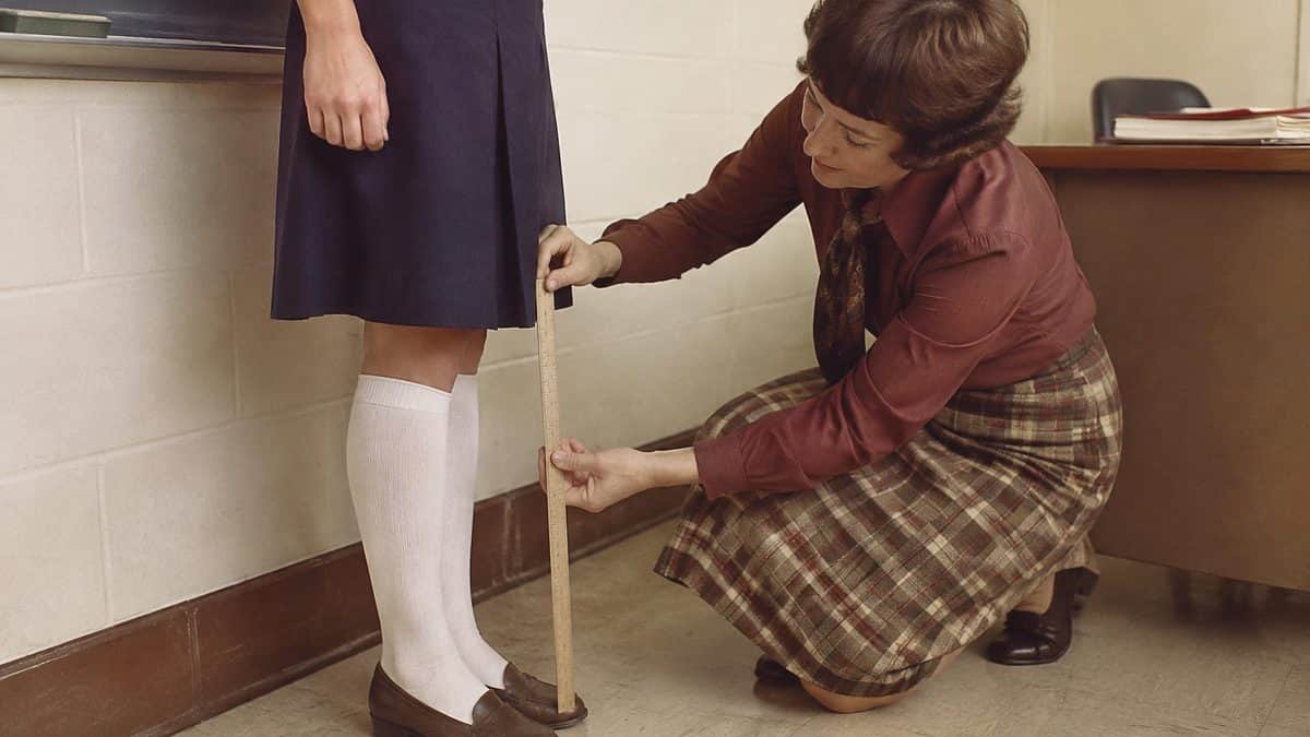 Teacher measuring a skirt hemline