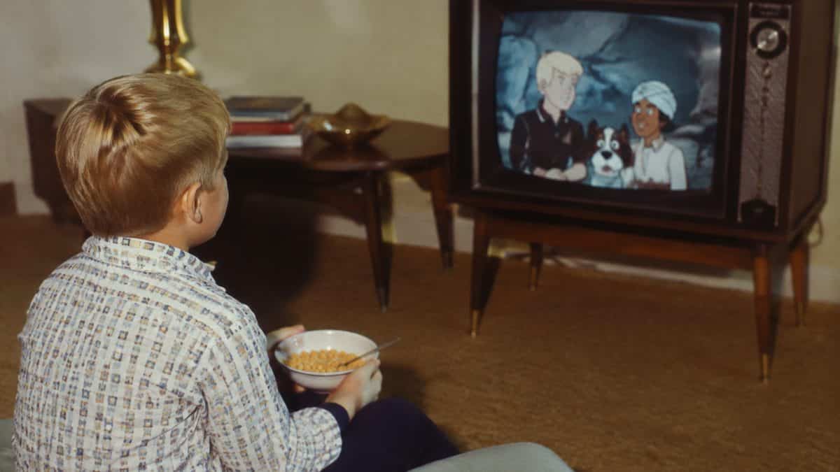 16 Saturday Morning Cartoons That Defined Your Childhood 14 Vintage 1960s photo of a child eating cereal while watching TV