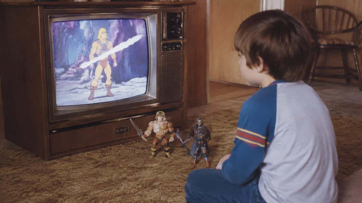 16 Saturday Morning Cartoons That Defined Your Childhood 16 Vintage 1980s photo of a child playing with action figures by a TV
