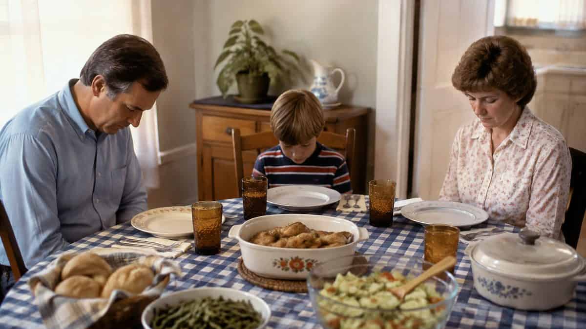 12 Forgotten Dinner Table Rules That Would Surprise Kids Today 13 Family bowing their heads in prayer before a meal
