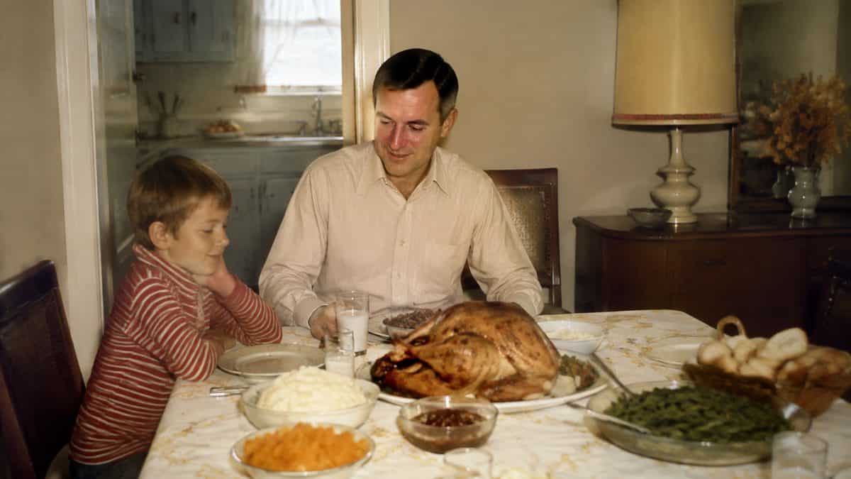 12 Forgotten Dinner Table Rules That Would Surprise Kids Today 6 Family gathered around a turkey