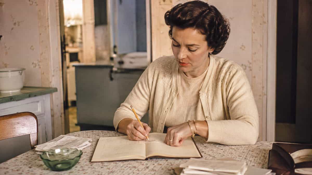 How '50s Moms Kept the Family Organized Without Any Tech 8 Woman writing in a ledger.