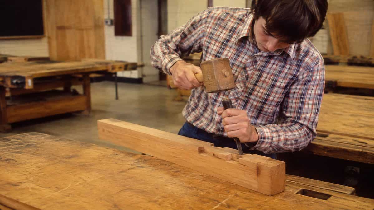 Student's hands properly holding a chisel and mallet.