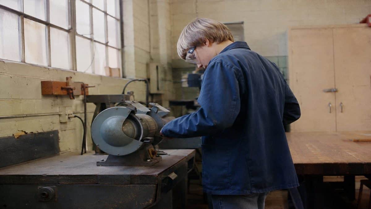 Student safely using a bench grinder.