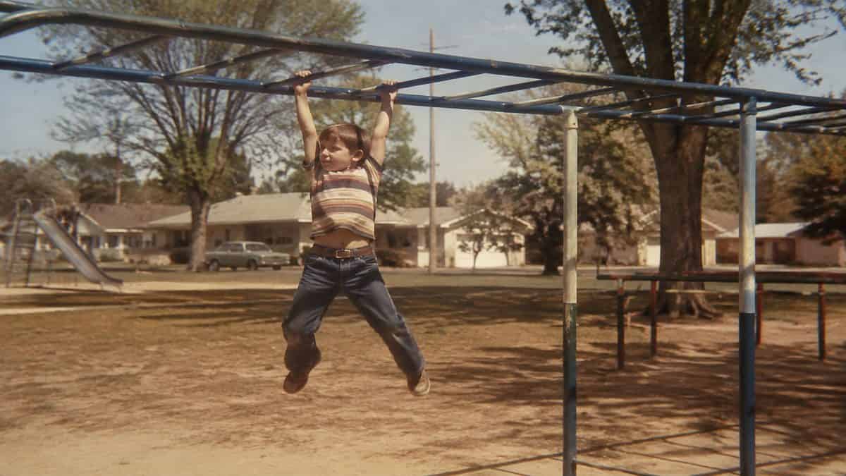 Remember These? 15 Playground Equipment Pieces That Would Never Pass Safety Standards Today 15 Vintage photo of a child playing on uneven bars or monkey bars.