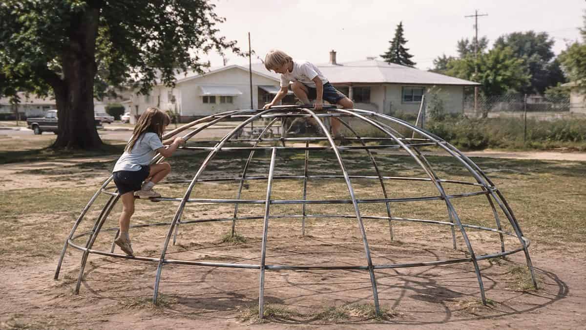 Remember These? 15 Playground Equipment Pieces That Would Never Pass Safety Standards Today 5 Genuine vintage photograph of children playing on a classic dome-shaped steel jungle gym.