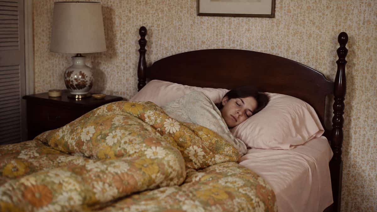Woman sleeping in a 1970s bedroom