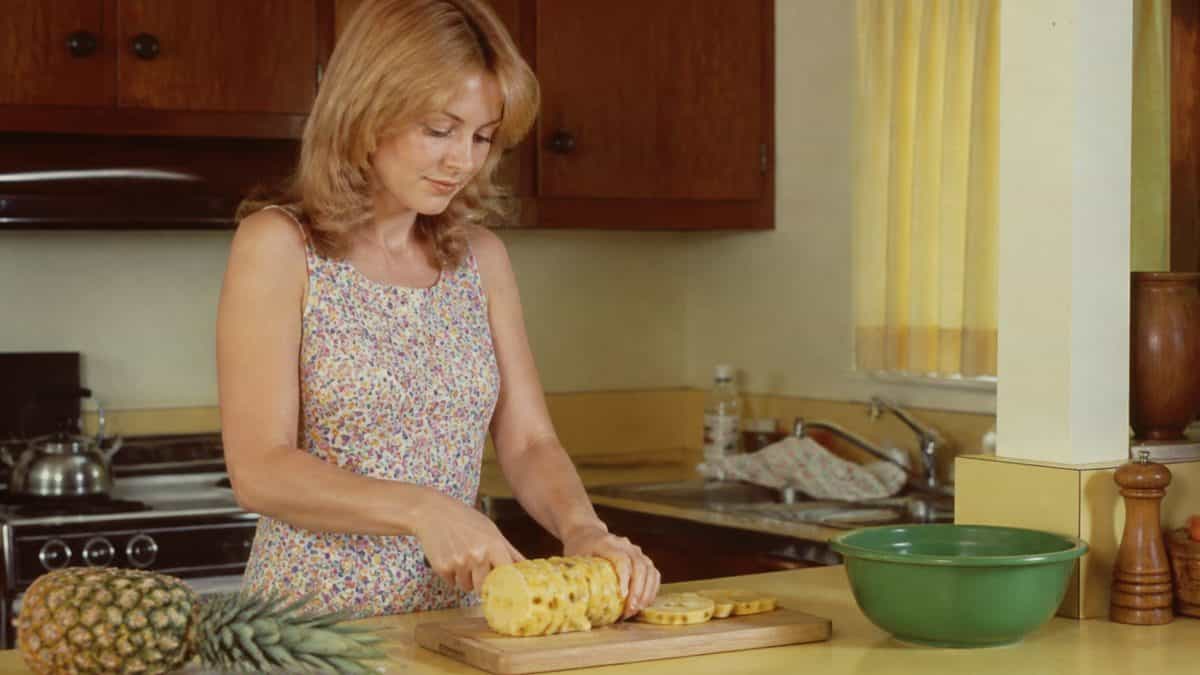 Someone preparing fresh pineapple.