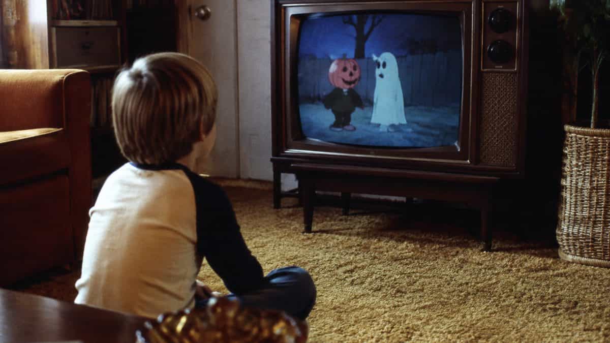 14 Things That Made Halloween Better in the '70s 9 Child watching a vintage TV in the 70s