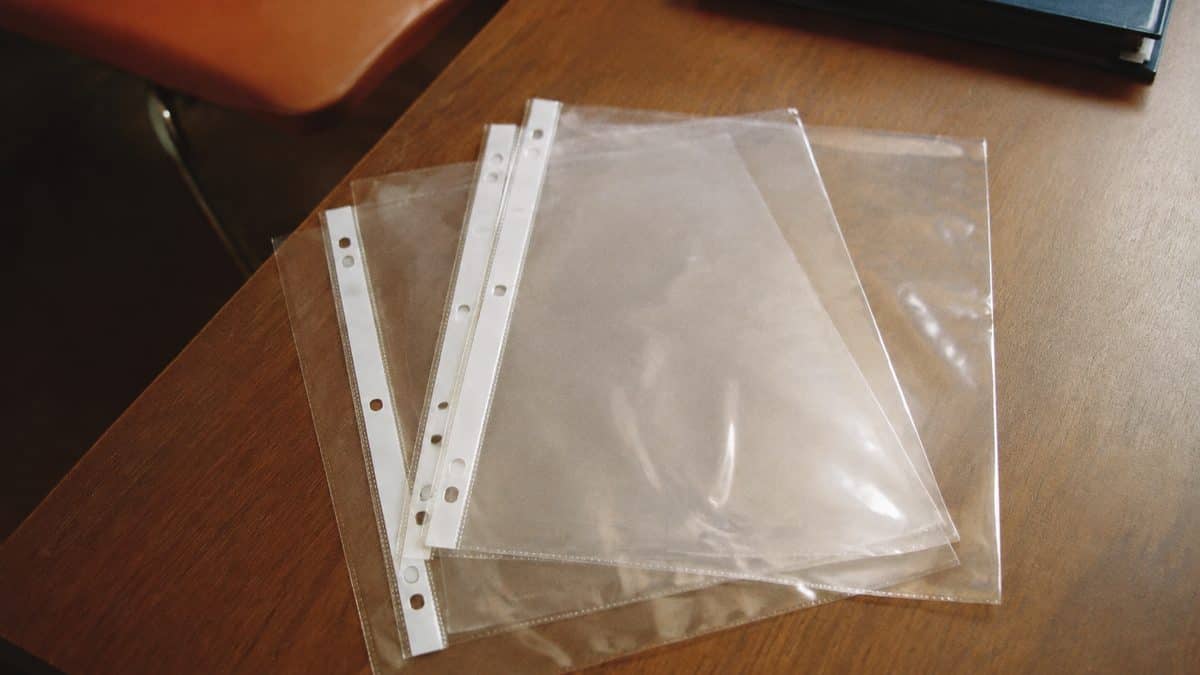 School Supplies Every '80s Kid Needed That Gen Alpha Wouldn't Recognize 3 Realistic photo of standard 3-ring clear plastic sheet protectors