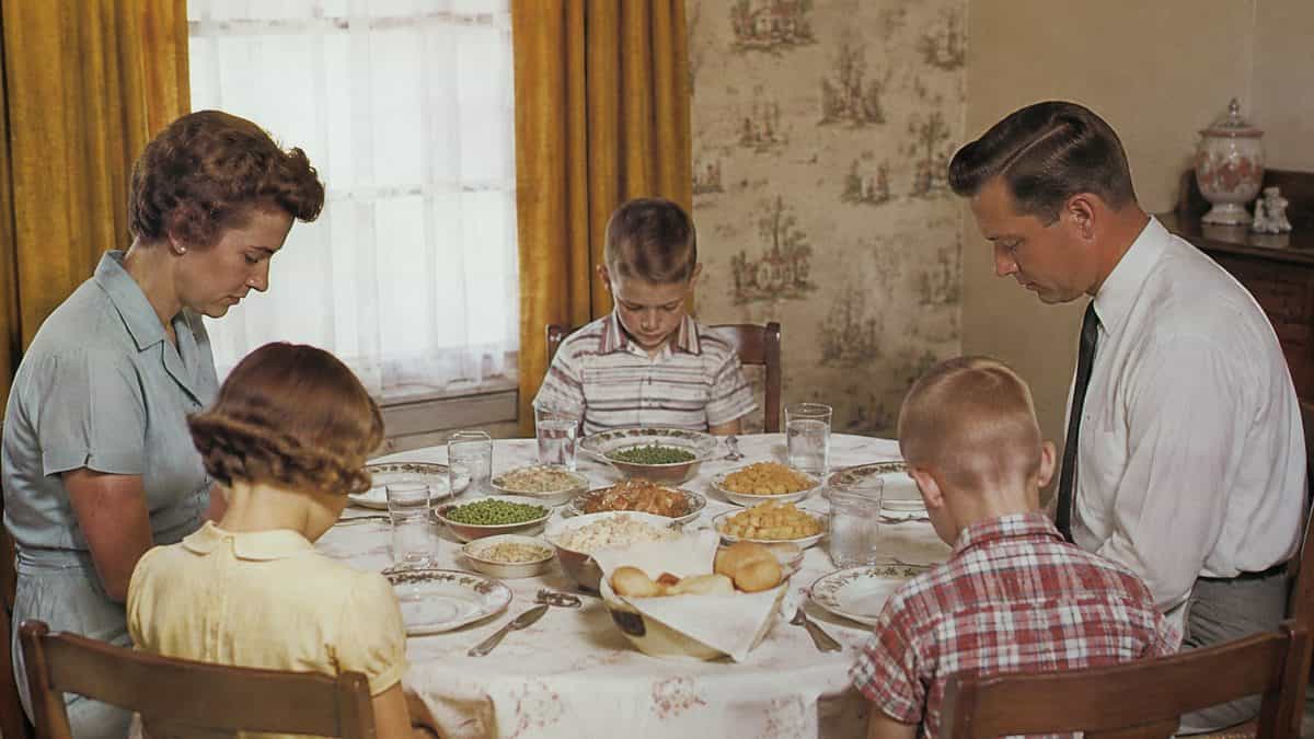 15 Ways Dinnertime Was Different in the '50s—And Why Families Miss It 7 Family saying grace at the dinner table