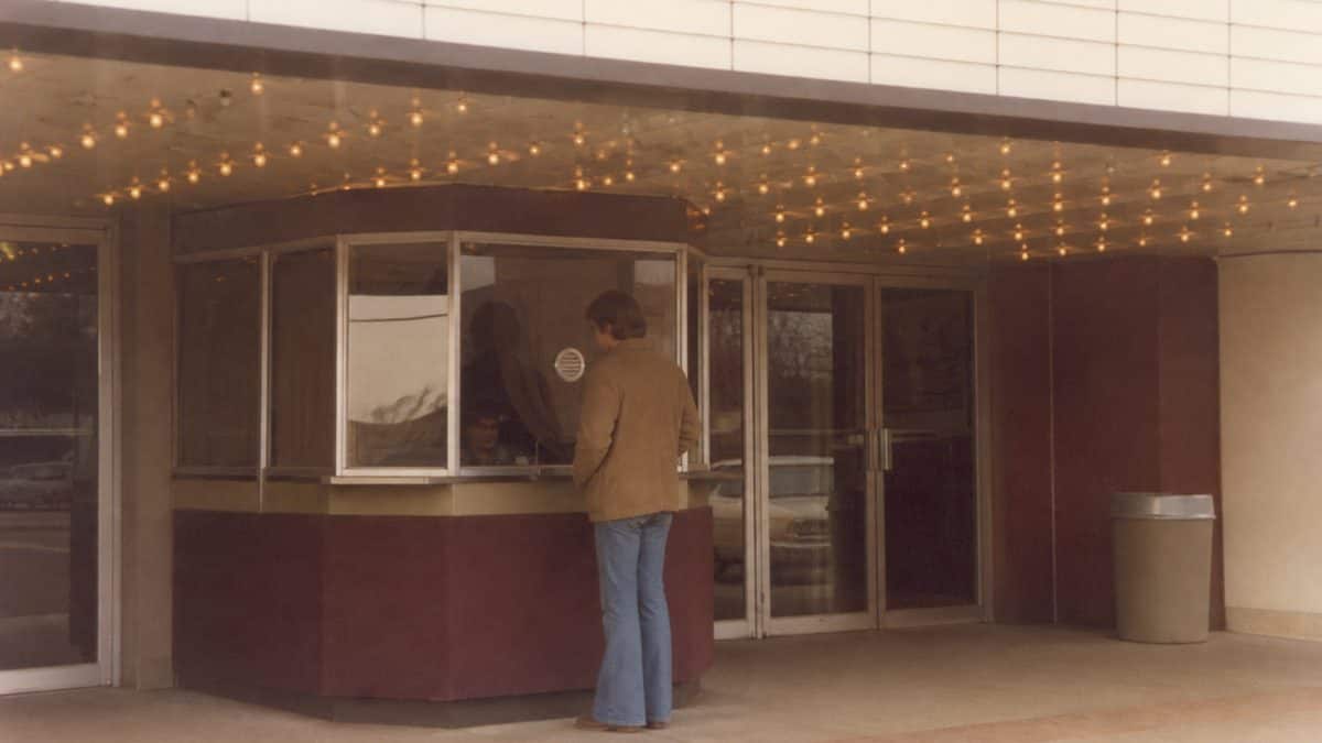 Authentic vintage photograph of a 1970s movie theater marquee or ticket booth.
