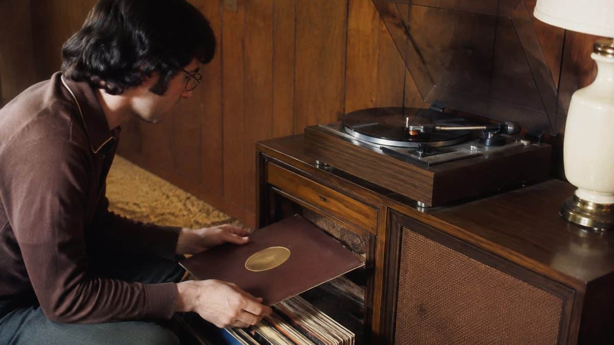 Real vintage photo of a 1970s record player or someone handling vinyl records.