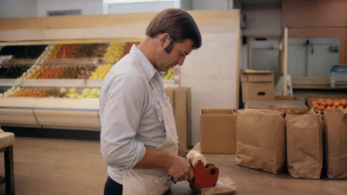 What Kids Used to Do at the Grocery Store That's Unthinkable Now 11 Grocery worker using manual price stamper