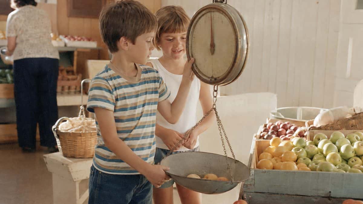 What Kids Used to Do at the Grocery Store That's Unthinkable Now 9 Authentic retro photo of kids interacting with hanging produce scale