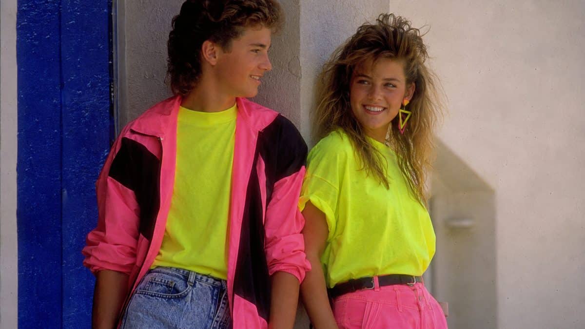 '80s Fashion Trends That Would Break the Internet Today 6 Vibrant, authentic 1980s photo of teenagers wearing neon clothing, smiling.