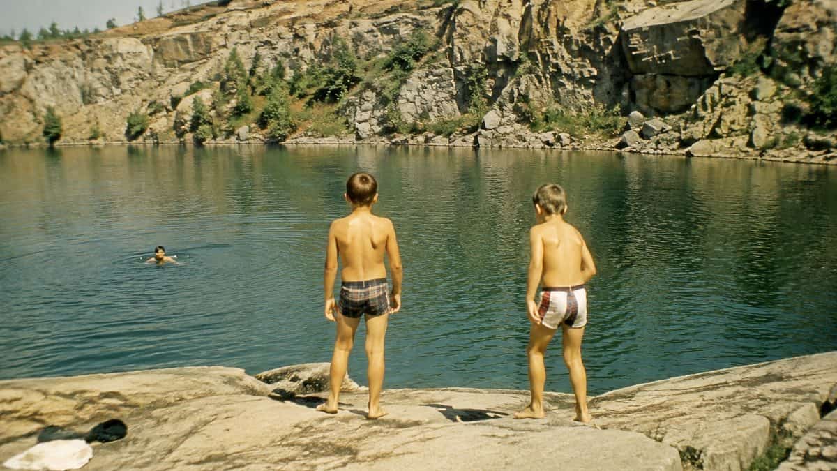 Real vintage snapshot of kids swimming or standing near a local quarry.