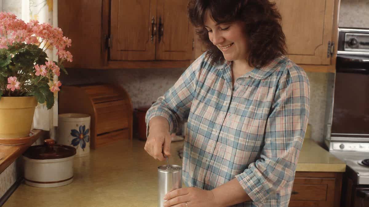 13 Items from Mom's Purse That Today's Kids Wouldn't Recognize 3 Smiling mother easily opening a juice can with a church key