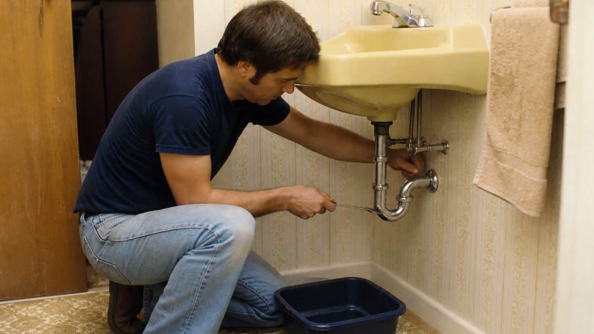 Household Skills Worth Relearning That Could Save You Thousands 11 Person fixing a sink