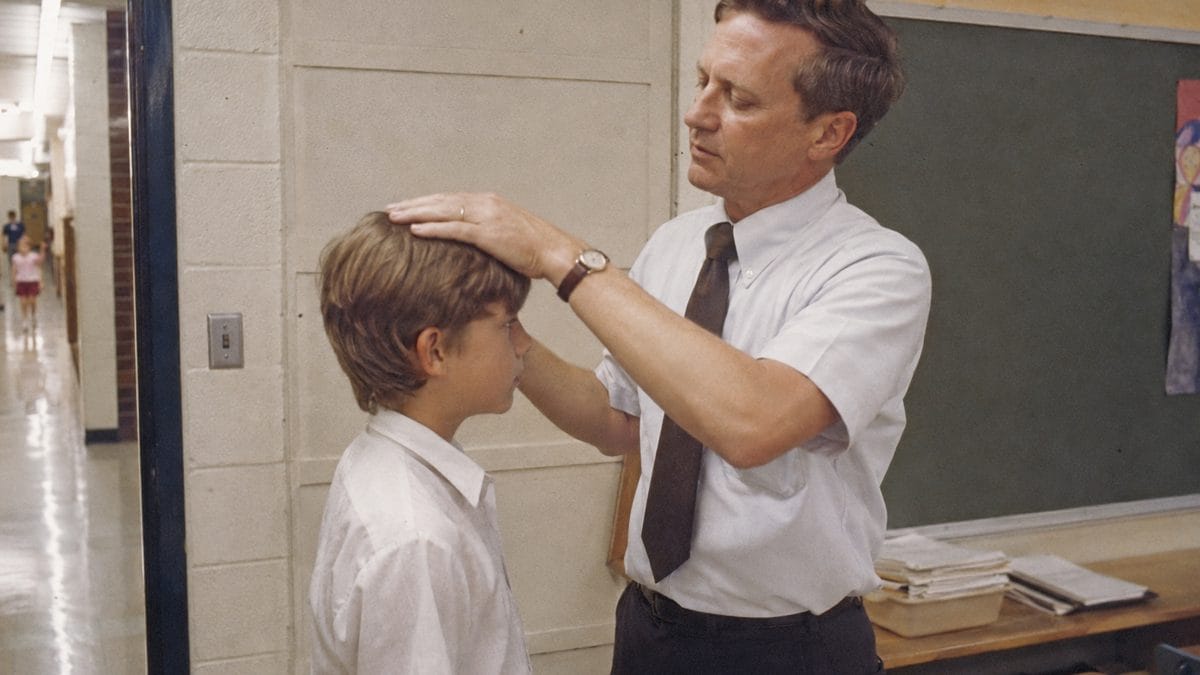 Teacher checking a student's haircut.