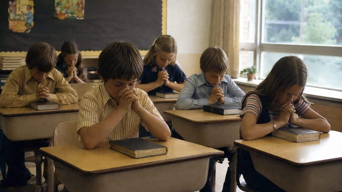 Students praying at desks