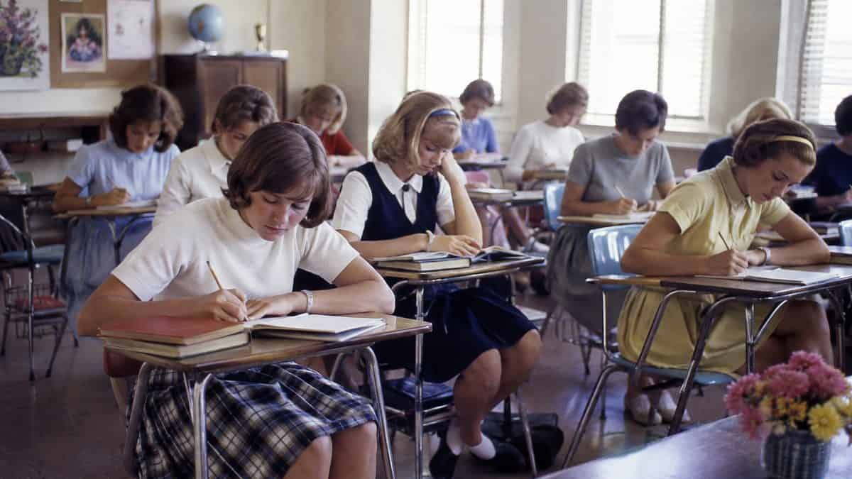 Authentic 1960s photo of female students wearing skirts or dresses at school.