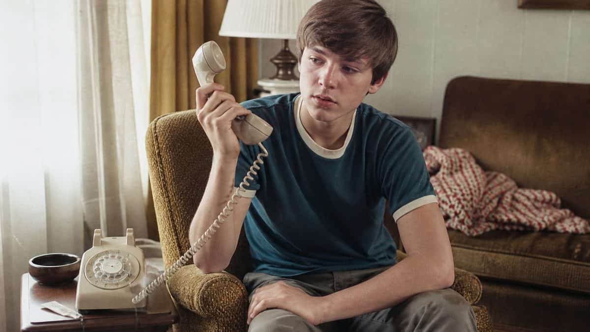 Someone holding a rotary phone receiver, looking confused by static
