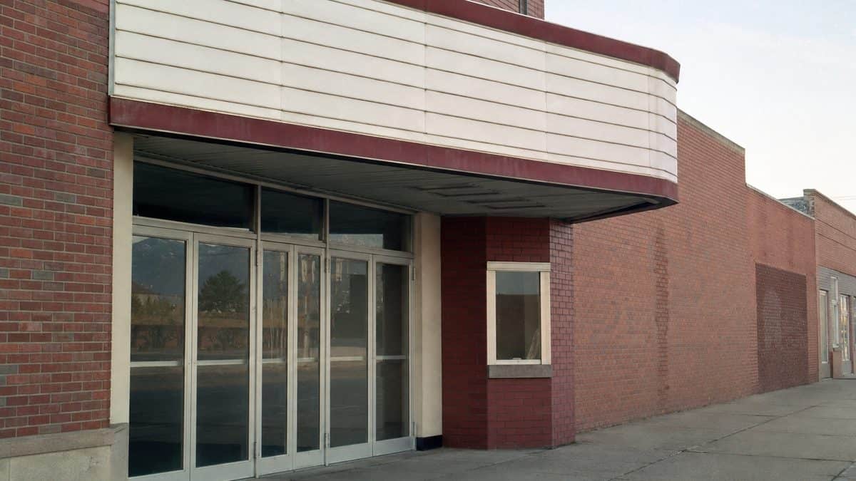 Empty 1970s movie theater entrance with blank marquee panels